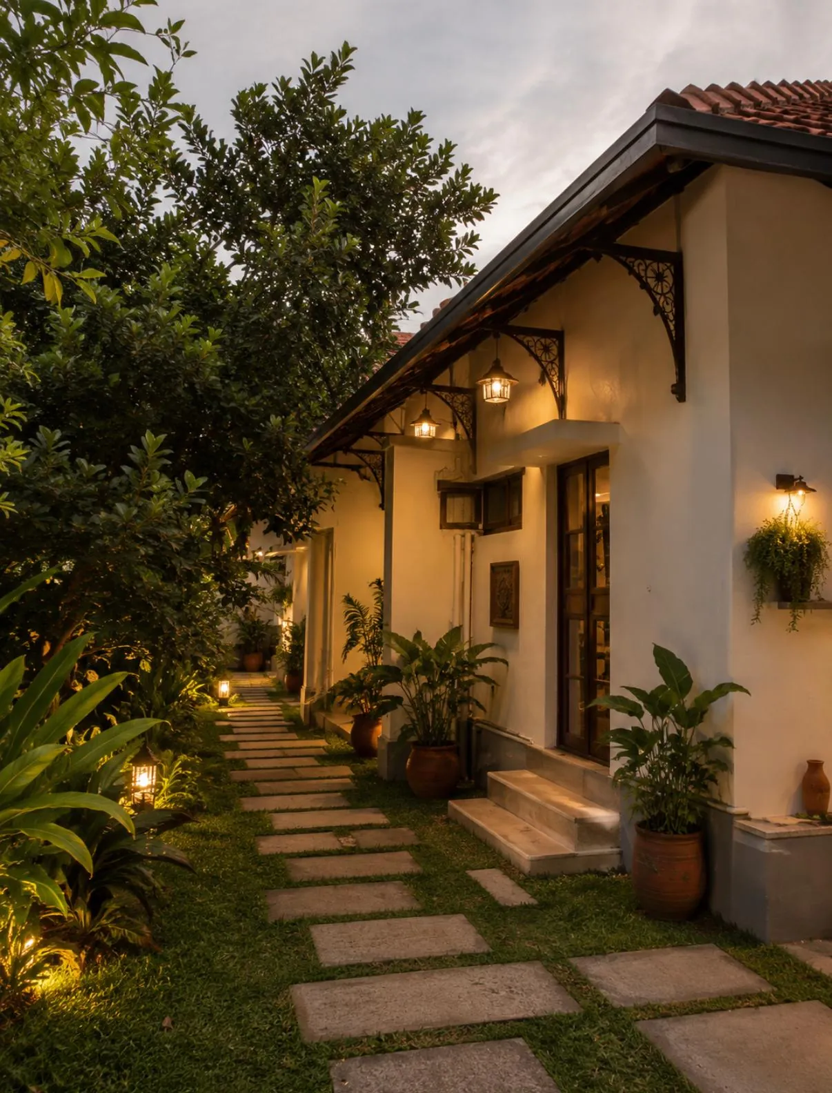 Lantern-lit garden walkway beside the private villa at dusk in Kannur, Kerala