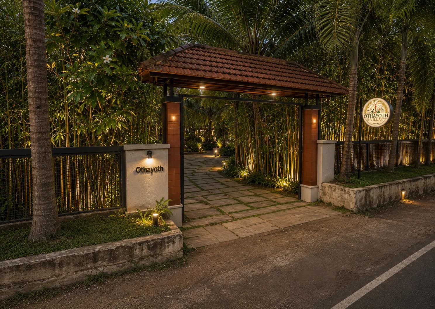 Gated private entrance of Othayoth Villa in Kannur, lit and framed by bamboo at dusk